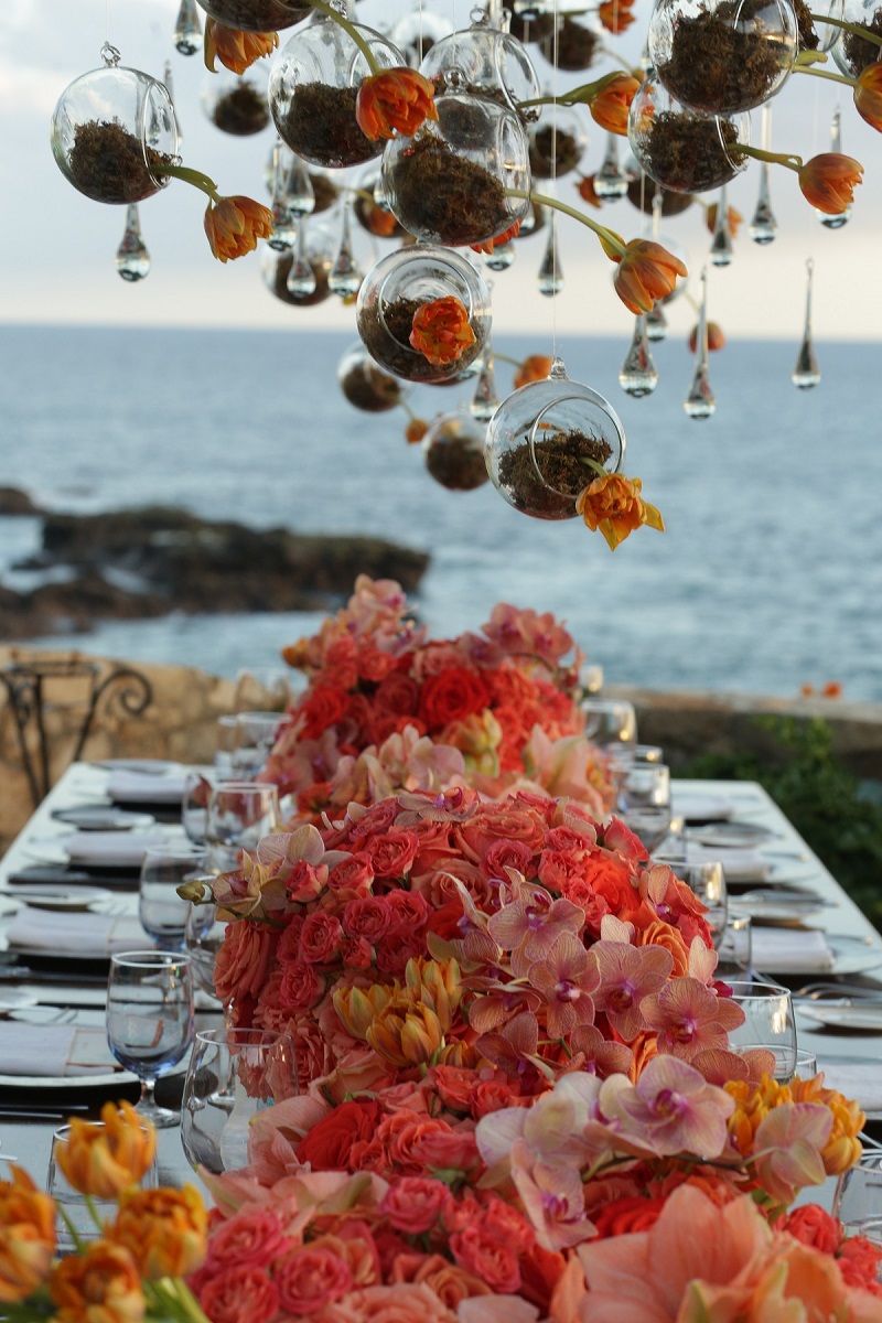 hanging flowers over wedding tables with orange and coral flowers elena damy event design 800jpg