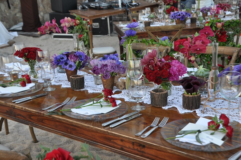 red and purple flowers beach weddings mexico elena damy floral design los cabos wooden tables lace linens 1