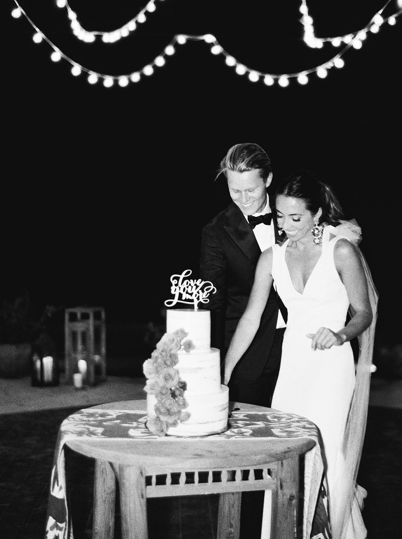 black-and-white-photo-of-bride-and-groom-cutting-the-cake-los-cabos-destination-weddings-elena-damy-destination-wedding-planners